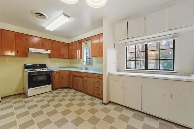 a kitchen with stainless steel appliances granite countertop a stove a sink and a refrigerator