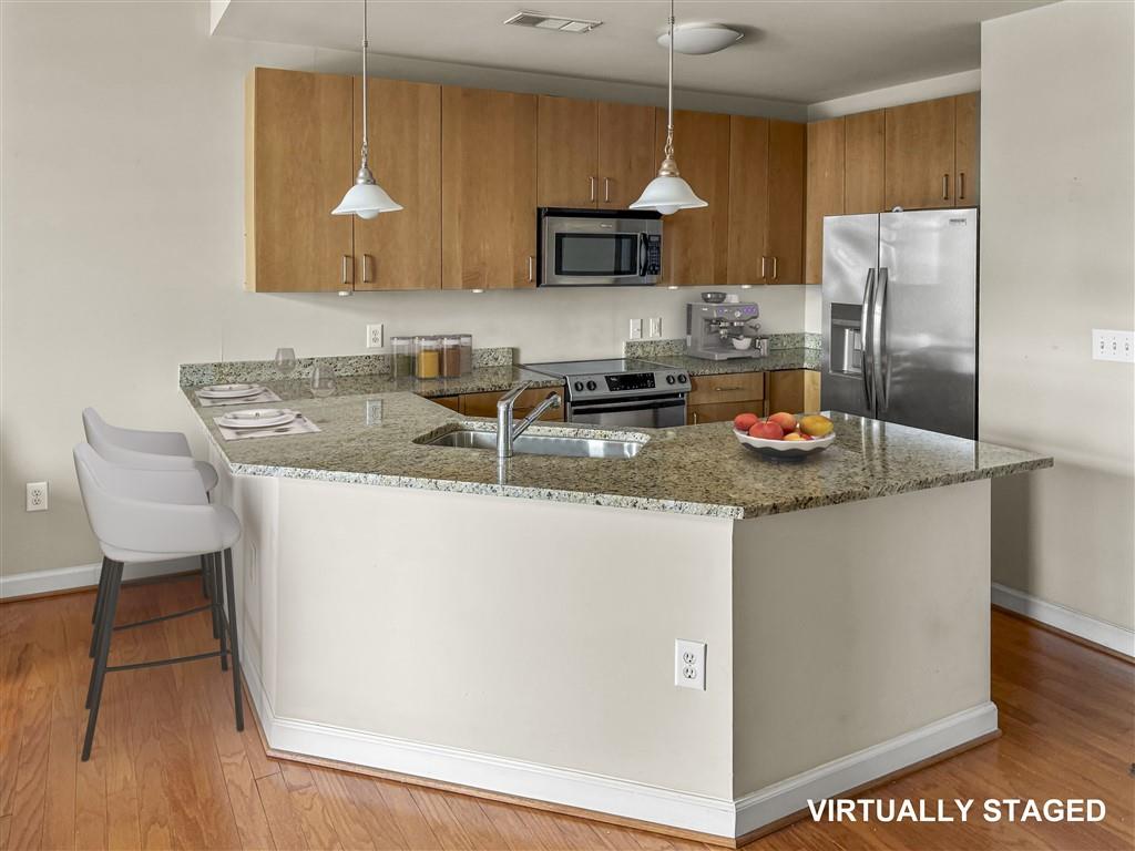 711 Cosmopolitan Drive Northeast, Unit 527 Atlanta, GA 30324 - Photo 5 of 9 a kitchen with stainless steel appliances granite countertop a sink a microwave a refrigerator and counter space