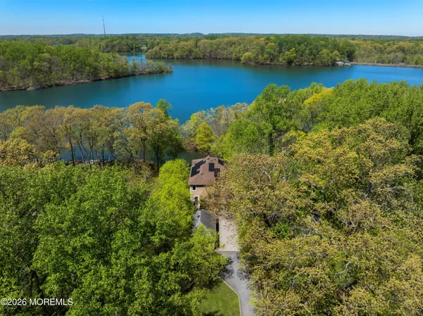 an aerial view of residential houses with outdoor space and lake view