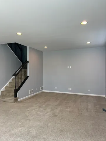 an empty room with stairs and white walls