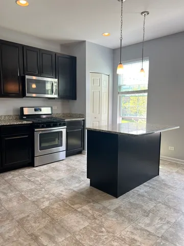 a kitchen with stainless steel appliances granite countertop a stove a sink and a refrigerator