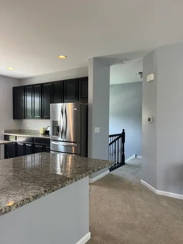 a kitchen with stainless steel appliances granite countertop a refrigerator a stove and a sink with granite countertops