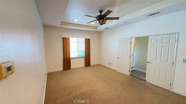 a view of a livingroom with a ceiling fan & entryway