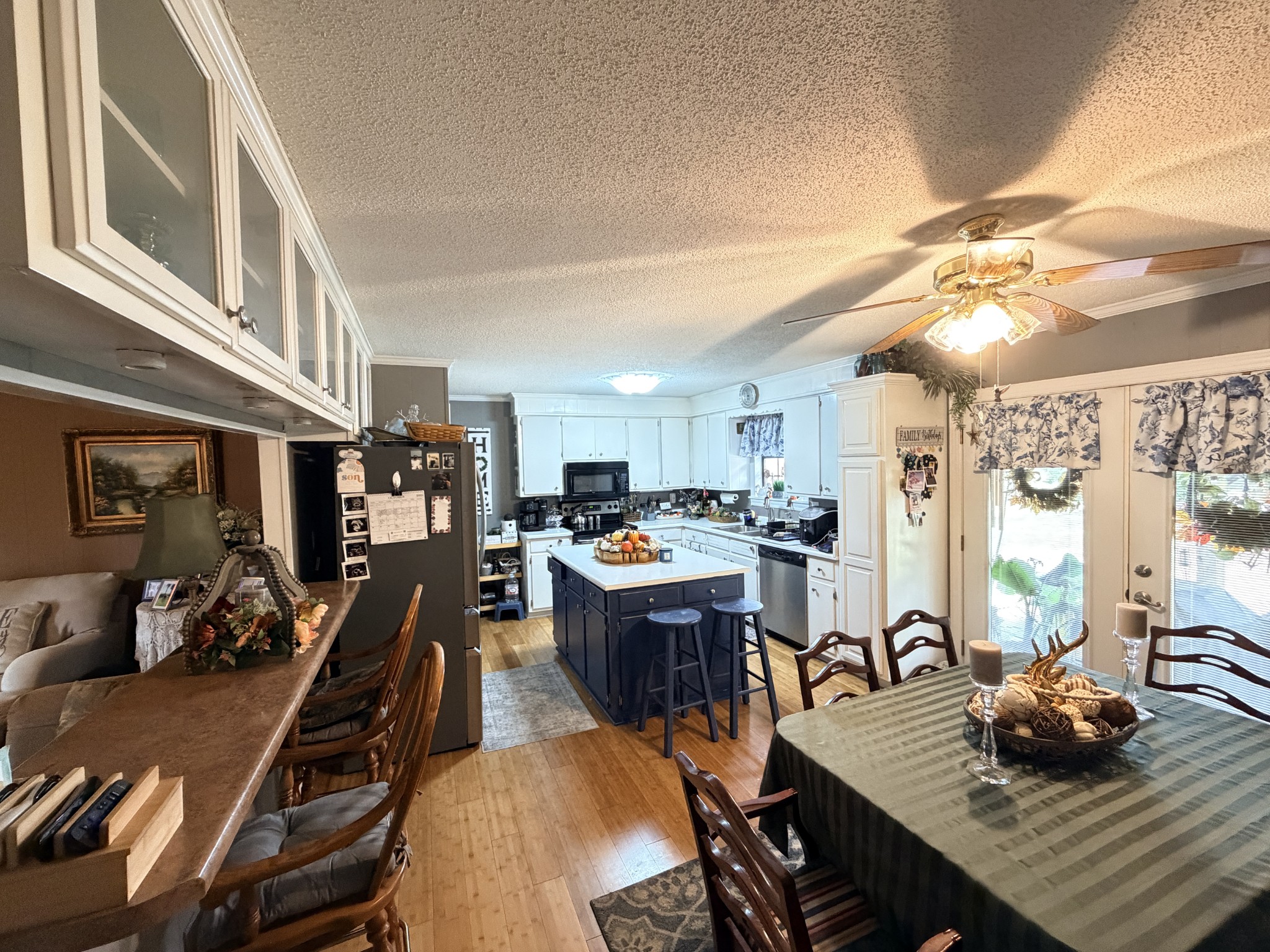 2890 Nance Bend Road Clifton, TN 38425 - Photo 8 of 52 a view of a dining room and livingroom with furniture wooden floor a rug a painting and a chandelier