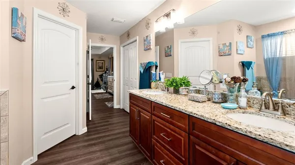 a bathroom with a granite countertop double vanity sink and a mirror