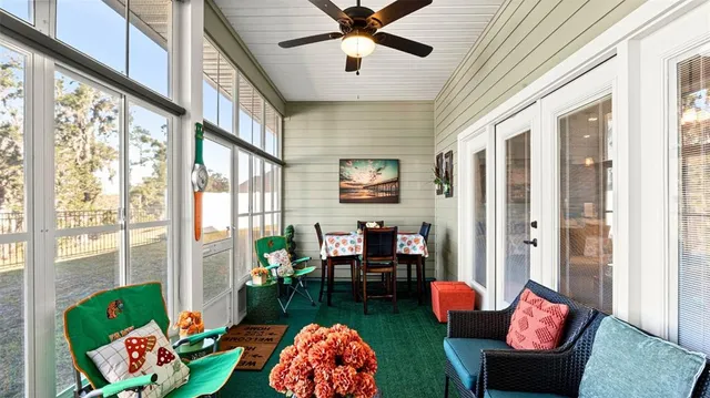 a living room with furniture and a floor to ceiling window