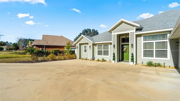 a front view of a house with a yard and potted plants