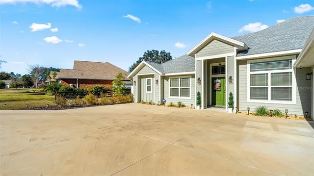 a front view of a house with a yard and potted plants