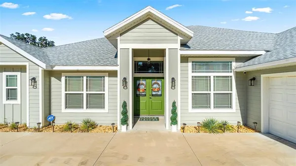 a front view of a house with a garden