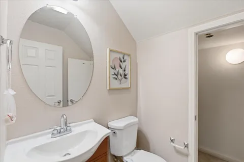 a bathroom with a toilet a sink and mirror