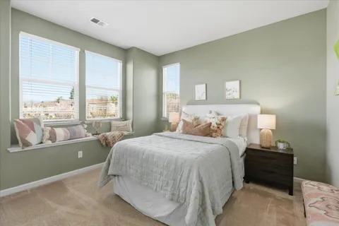 a bedroom with a bed and a large window
