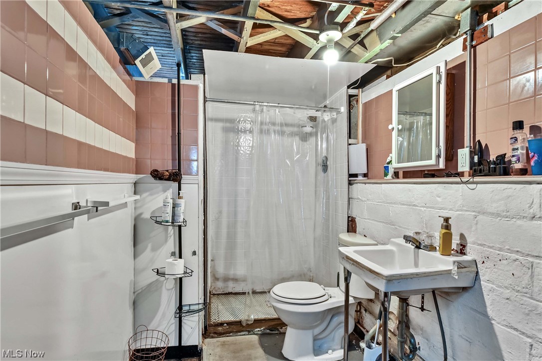 7705 Spring Garden Road Cleveland, OH 44129 - Photo 28 of 32 Bathroom with sink, toilet, and tile walls