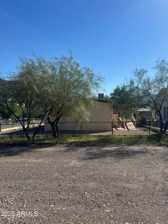 a view of a yard with a car parked in the road