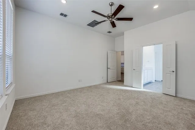 an empty room with a ceiling fan and a window