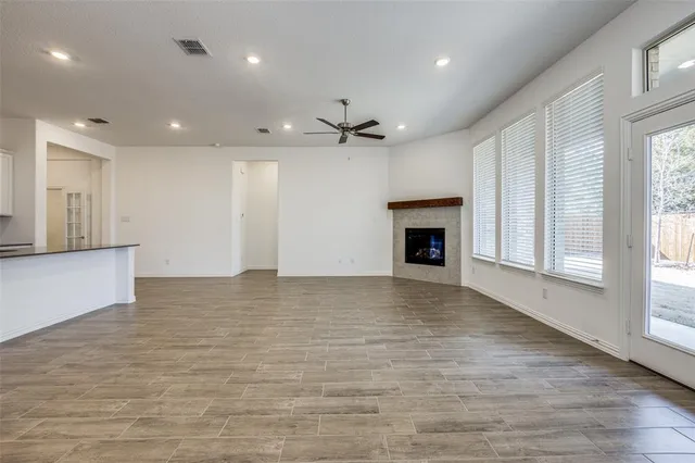 an empty room with windows and a fireplace