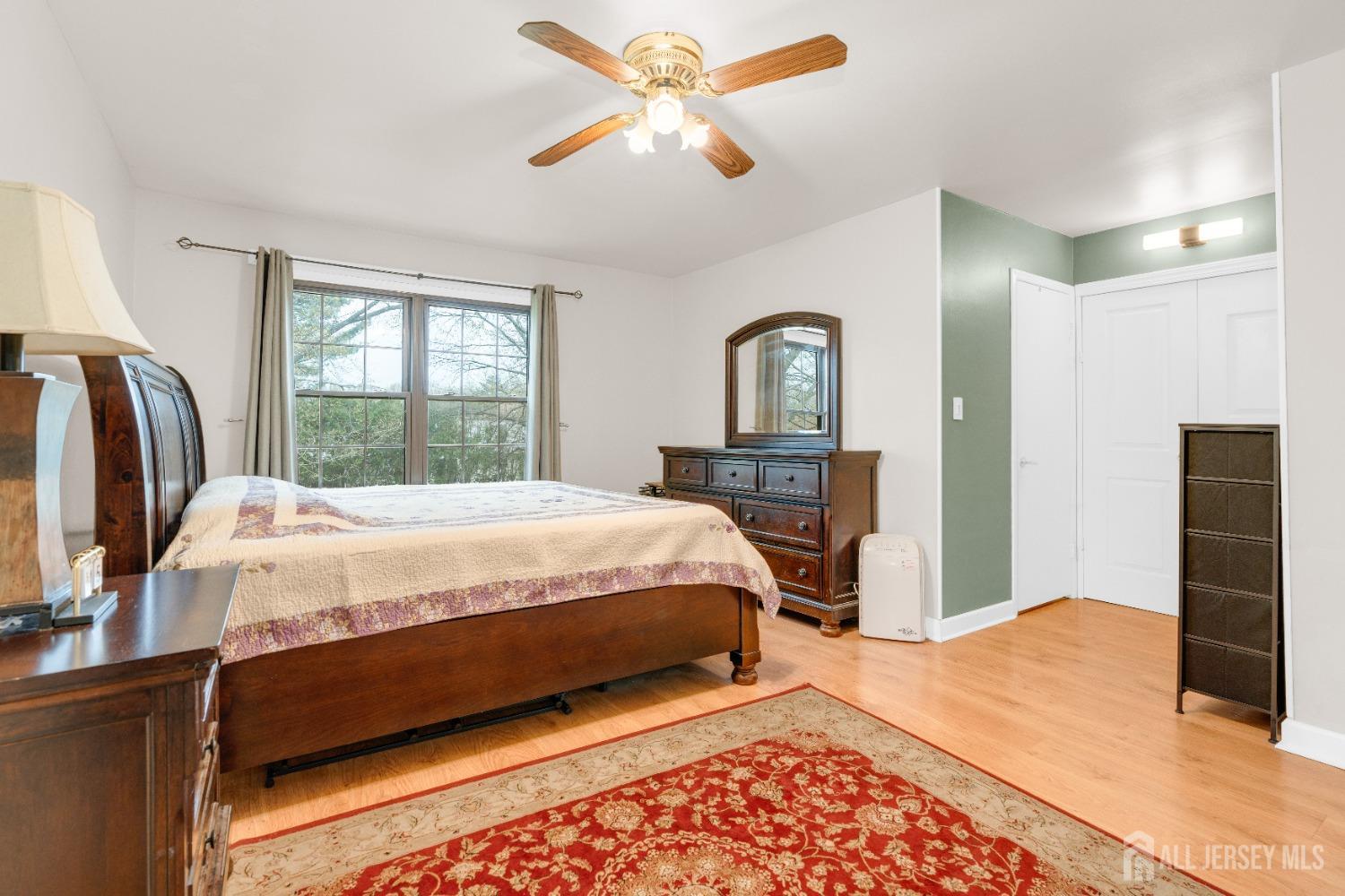 90 Pheasant Run Edison, NJ 08820 - Photo 20 of 39 a large bed sitting in a bedroom next to a window and a chandelier