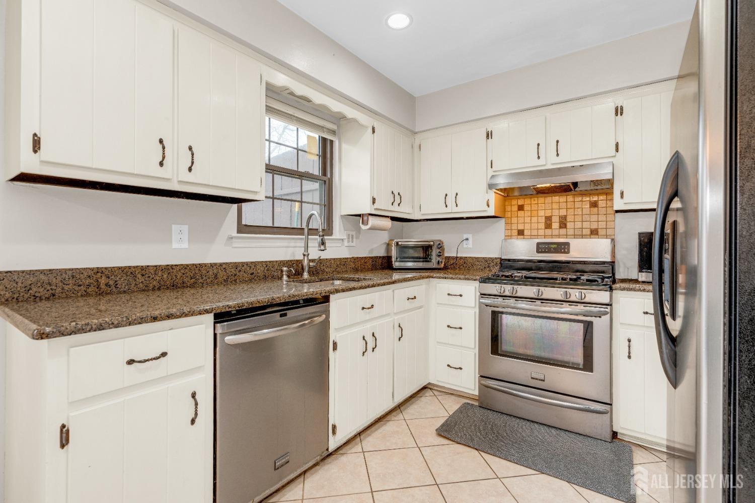 90 Pheasant Run Edison, NJ 08820 - Photo 9 of 39 a kitchen with granite countertop white cabinets and white appliances