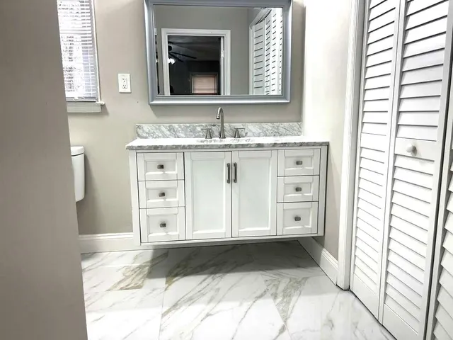 a bathroom with a granite countertop sink a vanity and a mirror