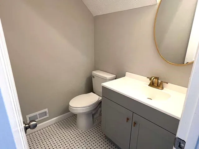 a bathroom with a sink toilet and a mirror