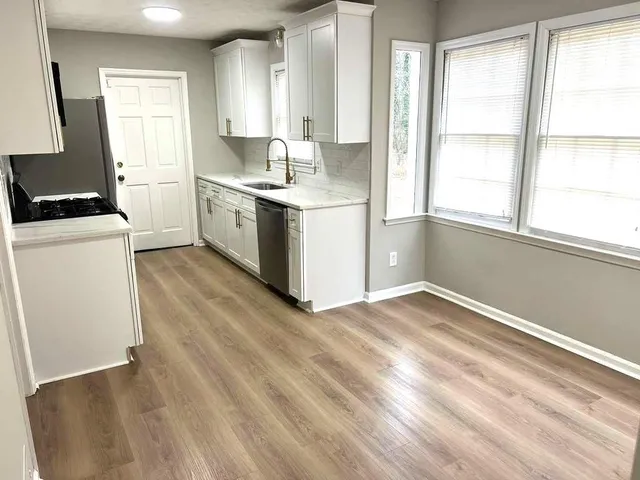 a kitchen with stainless steel appliances granite countertop a stove a sink and a microwave