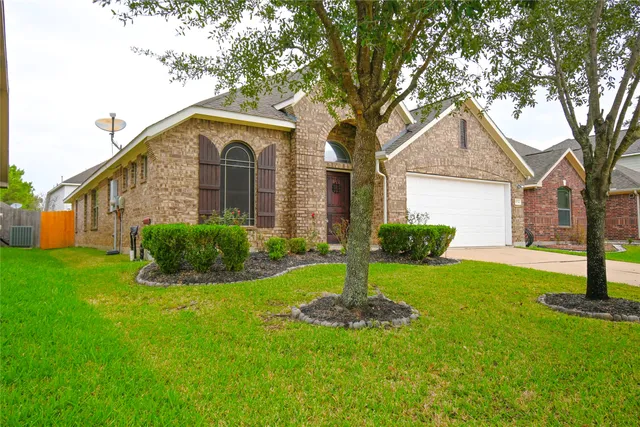 a front view of a house with a yard and trees