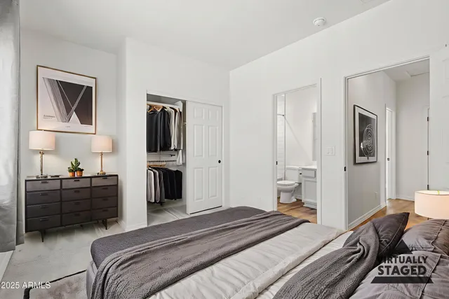 a view of a bathroom with closet and mirror