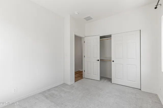 a bedroom with a large bed and a flat tv screen on dresser