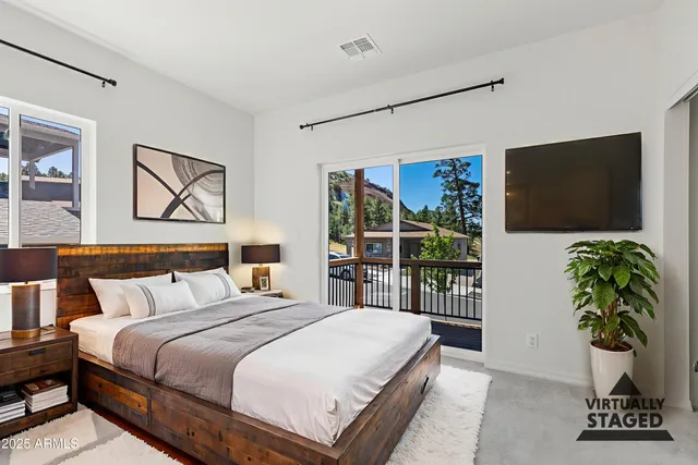 a bedroom with a large bed and a flat screen tv