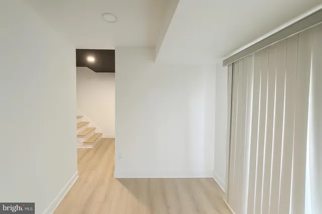 a view of a livingroom with wooden floor and a bathroom