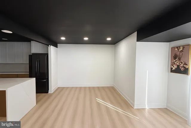 a view of kitchen with refrigerator and wooden floor