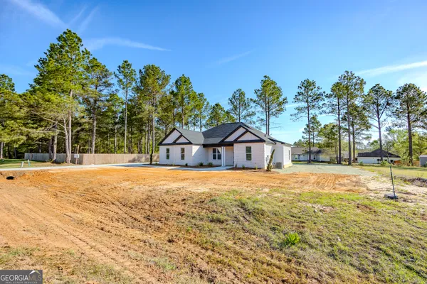 a view of a house with a big yard and large tree
