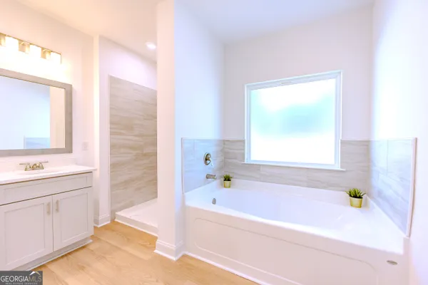 a bathroom with a granite countertop sink toilet a large mirror a shower and a bathtub