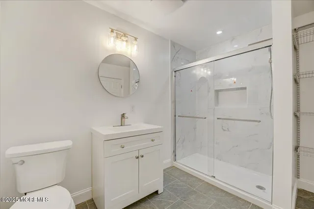 a bathroom with a toilet a sink a mirror and vanity