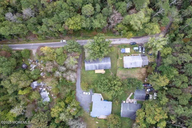 an aerial view of residential house with outdoor space and trees all around