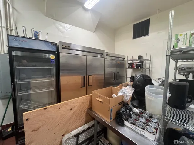 a kitchen with a refrigerator and a stove top oven