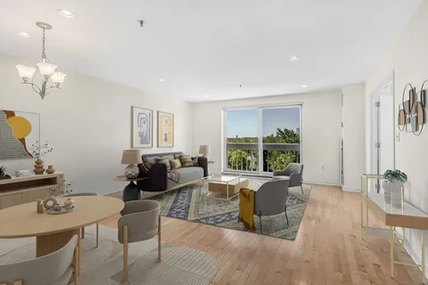 a living room with furniture two window and a table