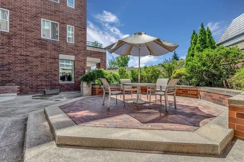 a view of a patio with a table and chairs under an umbrella