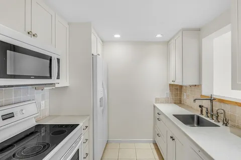 a kitchen with a sink stove and microwave