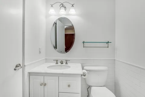 a bathroom with a toilet sink and mirror