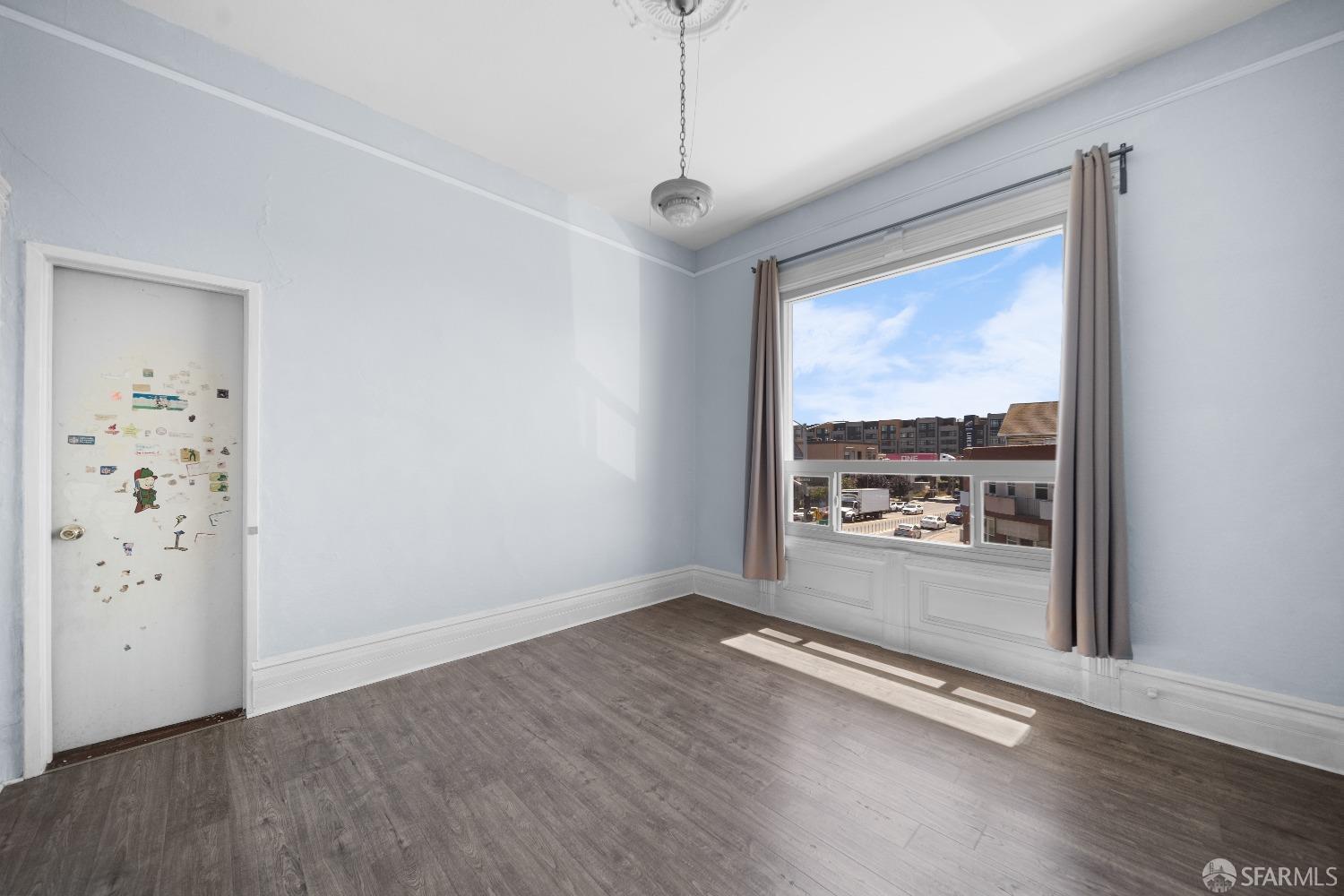 705 Jackson Street Oakland, CA 94607 - Photo 30 of 40 an empty room with wooden floor and windows