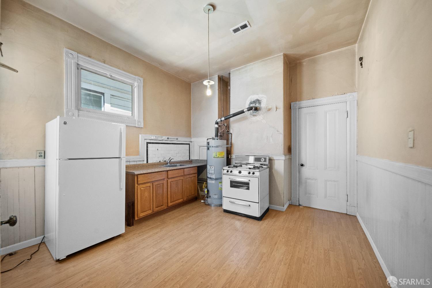 705 Jackson Street Oakland, CA 94607 - Photo 36 of 40 a kitchen with refrigerator cabinets and wooden floor