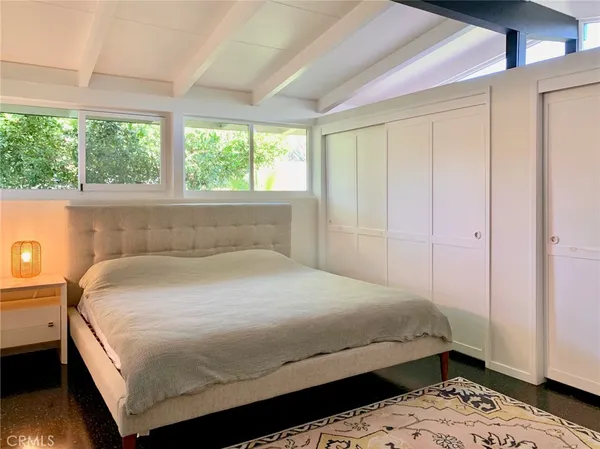 a bedroom with a bed and wooden floor