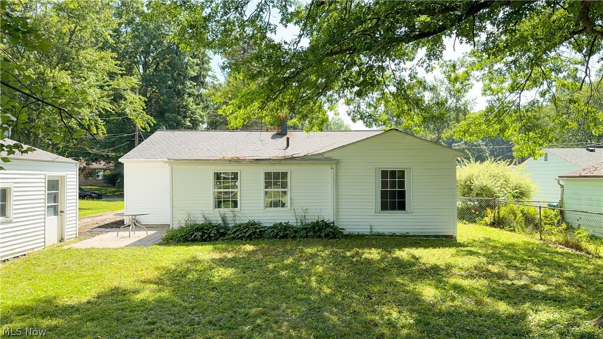 3796 North Santom Road Stow, OH 44224 - Photo 21 of 30 Rear exterior featuring white horizontal siding, a gray shingle roof, multiple windows, and a concrete patio
