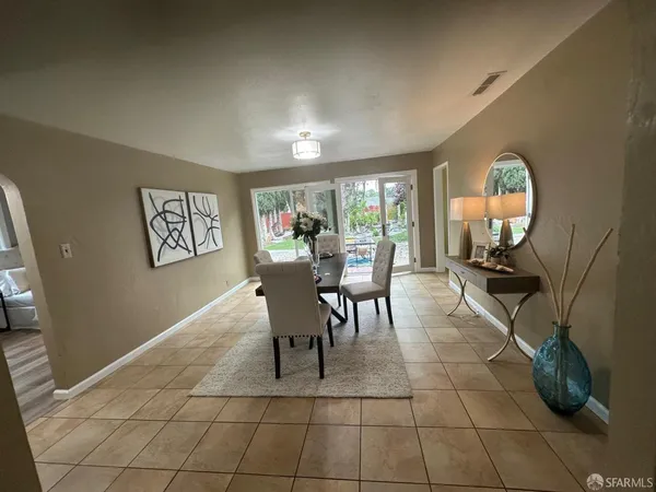 a dining room with furniture and a floor to ceiling window