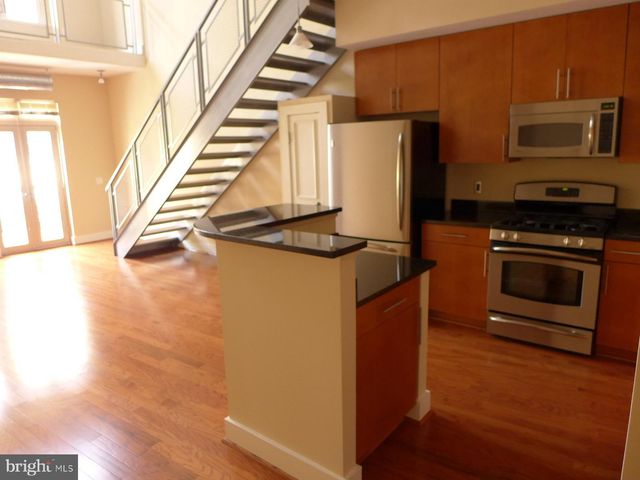 a kitchen with stainless steel appliances granite countertop a stove a microwave and a refrigerator