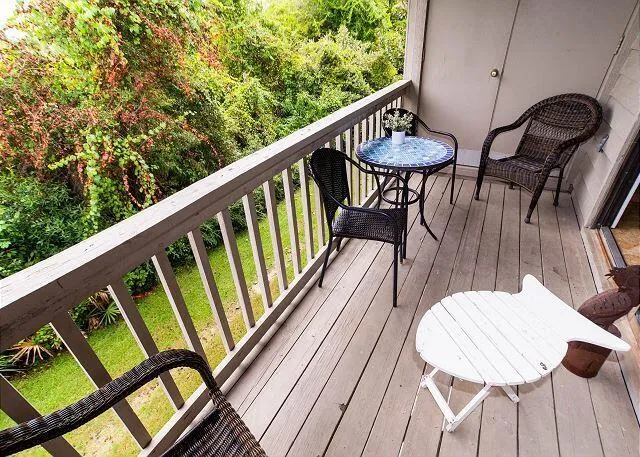 a balcony with wooden floor and outdoor seating