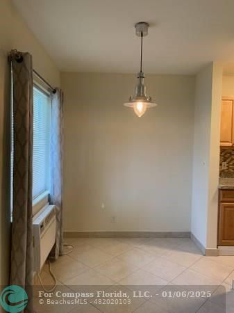 120 Northeast 10th Avenue, Unit 1 Hallandale Beach, FL 33009 - Photo 11 of 18 a view of a room with a door and a window