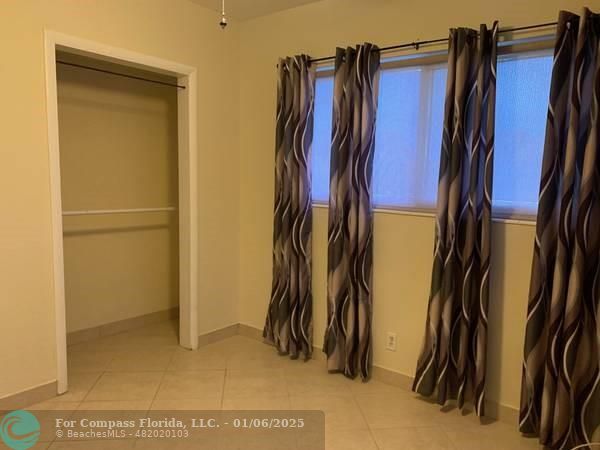 120 Northeast 10th Avenue, Unit 1 Hallandale Beach, FL 33009 - Photo 14 of 18 a view of walk in closet with clothes and shoes