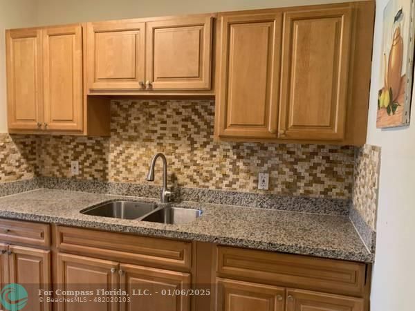 120 Northeast 10th Avenue, Unit 1 Hallandale Beach, FL 33009 - Photo 15 of 18 a kitchen with granite countertop a sink and a granite counter tops