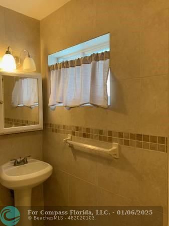 120 Northeast 10th Avenue, Unit 1 Hallandale Beach, FL 33009 - Photo 18 of 18 a bathroom with a sink a mirror and a toilet